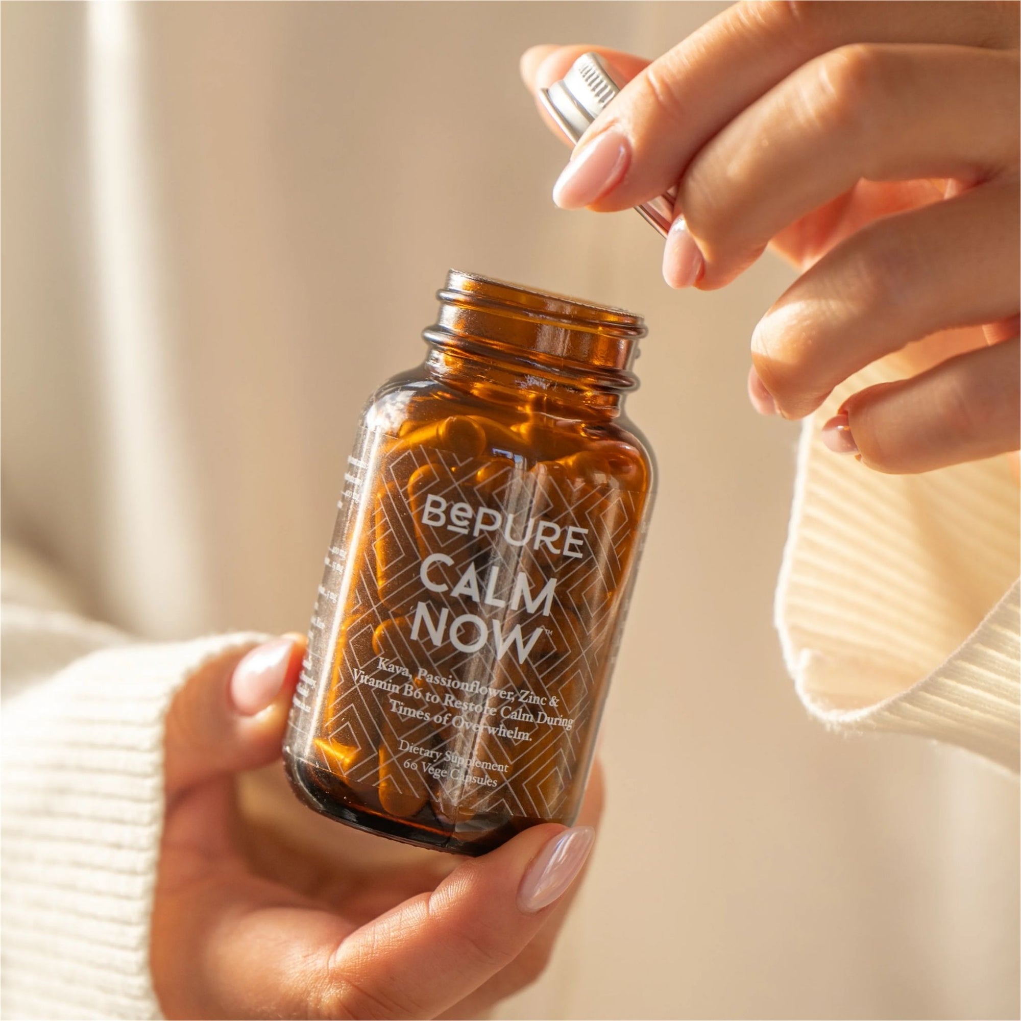 Hand holding a bottle labeled 'Bepure Calm Now' with a blurred background