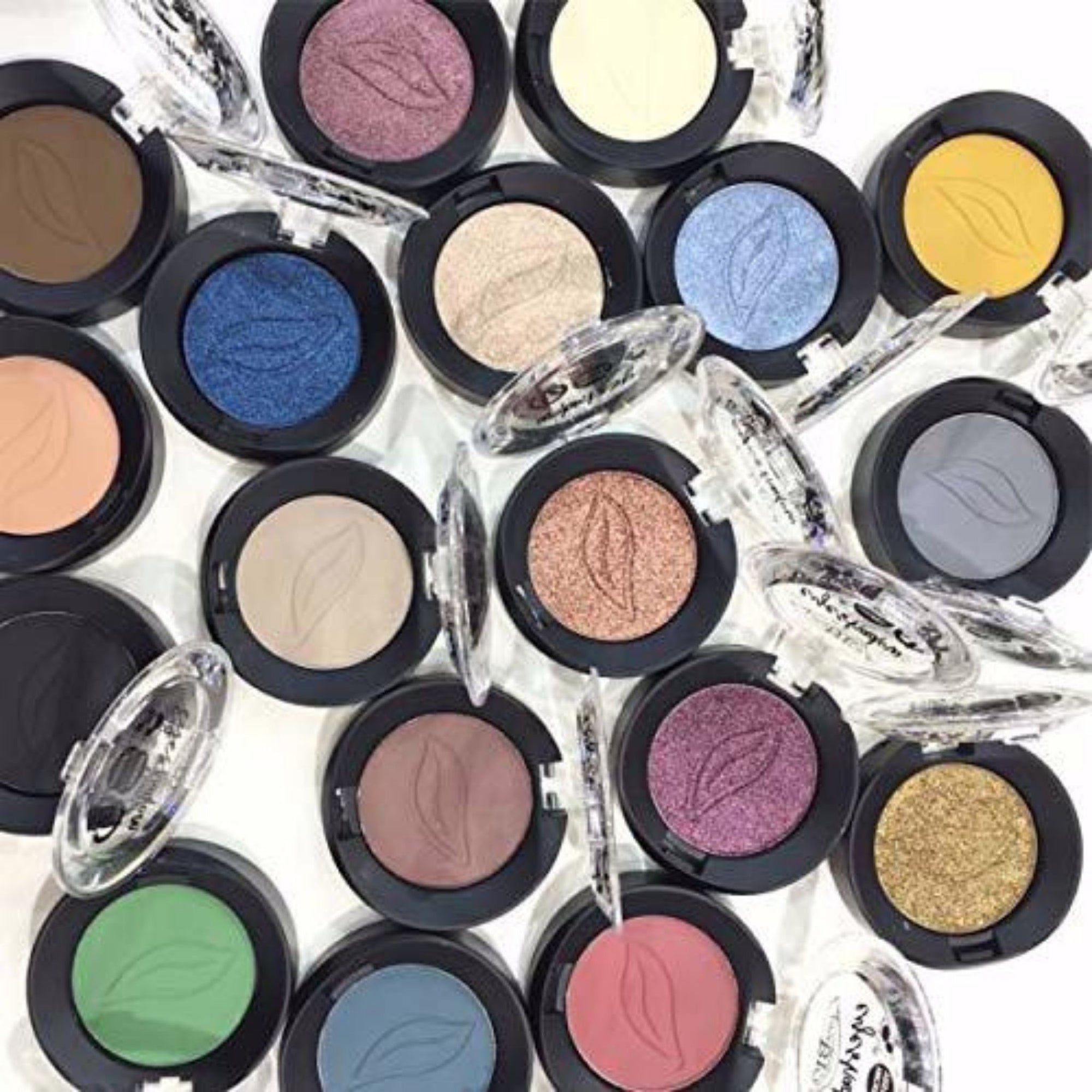 Collection of colorful PuroBIO Compact Eyeshadow pots with clear lids on a white background